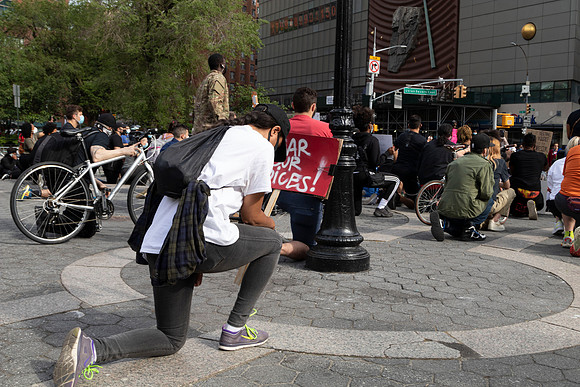 A protester kneels at rally against police violence in Union Square, NYC