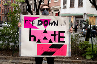 A man holding up a sign at a protest against hate and police violence in Greenwich Village
