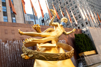 Statue of Prometheus wearing a face mask at Rockefeller Center