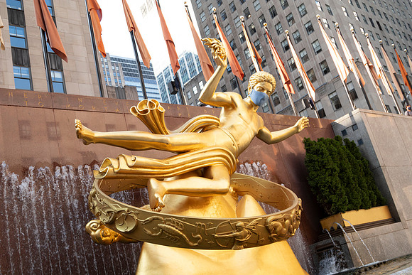 Statue of Prometheus wearing a face mask at Rockefeller Center